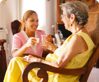 caregiver giving water to a senior woman